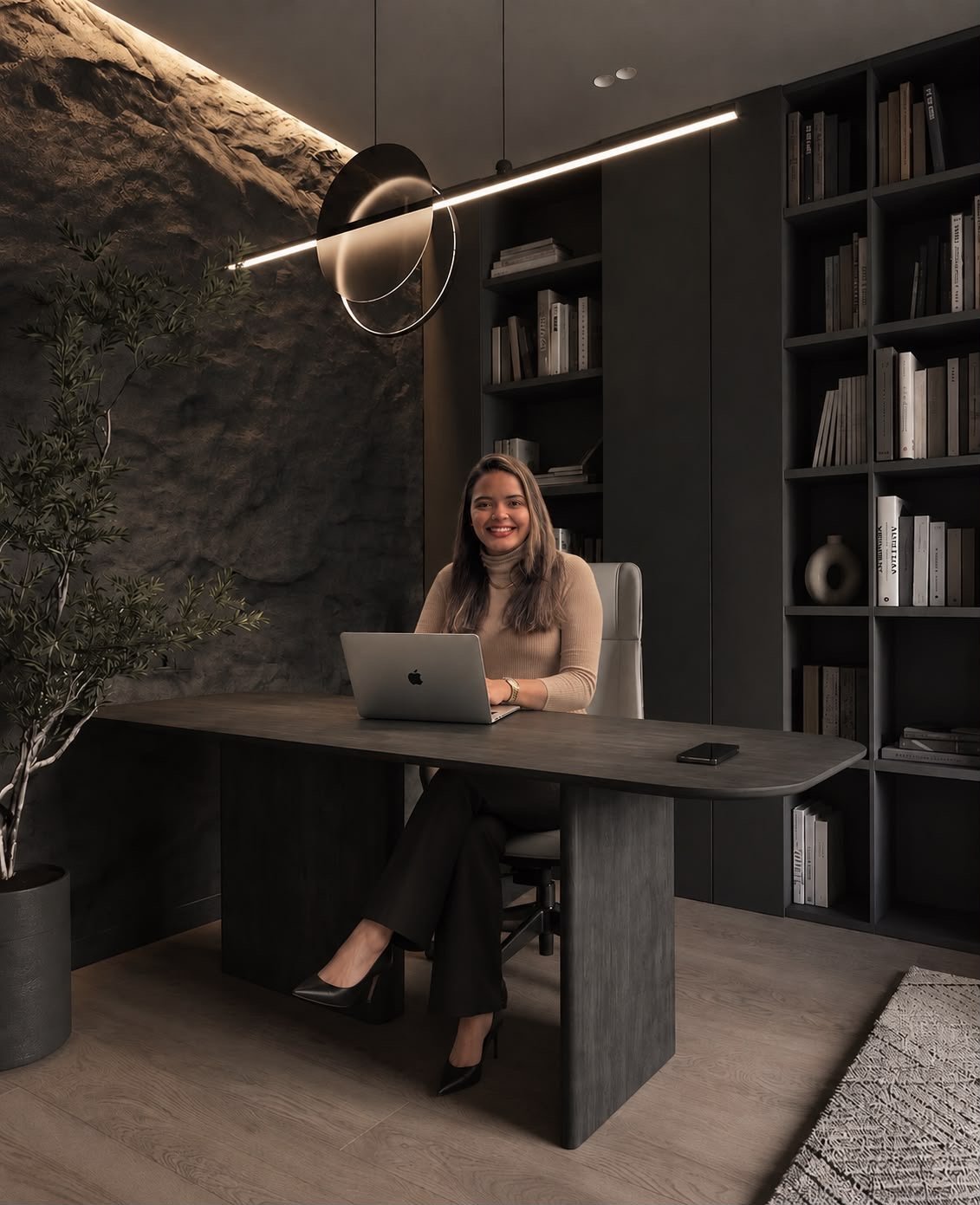 Sarah Caroline de Andrade em seu escritório, sentada à mesa de trabalho